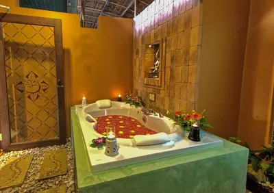 a bathroom with a bath tub with a large circle of flowers at Mangosteen Ayurveda & Wellness Resort - SHA Plus in Rawai Beach