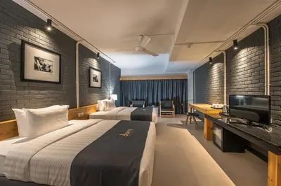 a hotel room with two beds and a television at DARA Hotel in Phuket Town