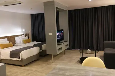 a hotel room with two beds and a television at DARA Hotel in Phuket Town