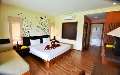 a bedroom with a large white bed with flowers on it at Phi Phi Arboreal Resort in Phi Phi Don