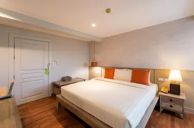 a bedroom with a large white bed with orange pillows at Aonang All Seasons Beach Resort in Ao Nang Beach