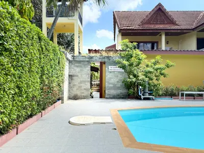 a swimming pool in front of a house at Family Bungalow Kamala in Kamala Beach