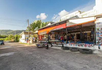 a street with a store with a motorcycle parked in front at Family Bungalow Kamala in Kamala Beach