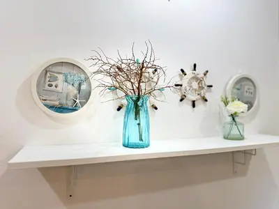 a blue vase sitting on a shelf with two mirrors at Family Bungalow Kamala in Kamala Beach