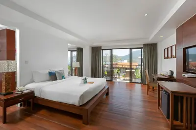 a bedroom with a large bed and a television at Baan Laimai Beach Resort & Spa - SHA Extra Plus in Patong Beach