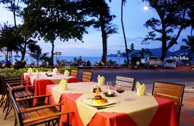 a row of tables with red and white table cloths at Baan Laimai Beach Resort & Spa - SHA Extra Plus in Patong Beach