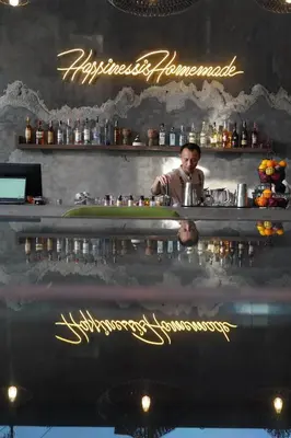 a man behind a bar with a reflection in the water at Baan Laimai Beach Resort & Spa - SHA Extra Plus in Patong Beach
