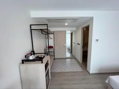 a living room with a table and a mirror at Hotel Midtown Ratsada in Phuket Town