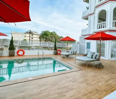 a pool on the roof of a house with red umbrellas at Hotel Midtown Ratsada in Phuket Town