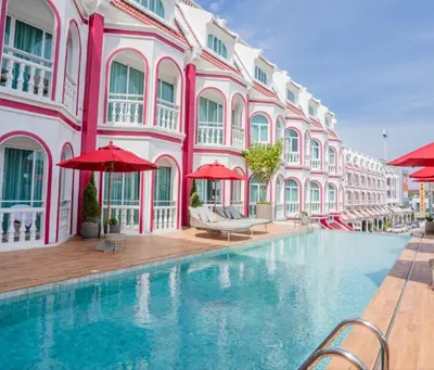 a swimming pool in front of a pink building at Hotel Midtown Ratsada in Phuket Town