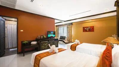 a bedroom with three beds and a television at Aonang Orchid Resort in Ao Nang Beach