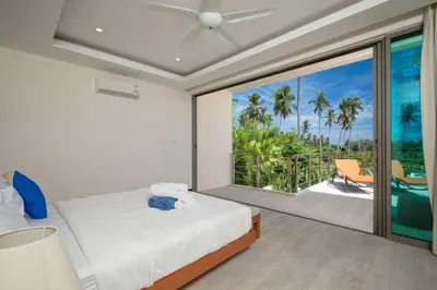 a bedroom with a bed and a view of the ocean at VILLA BAWAL 4BR Private pool villa in Rawai Beach