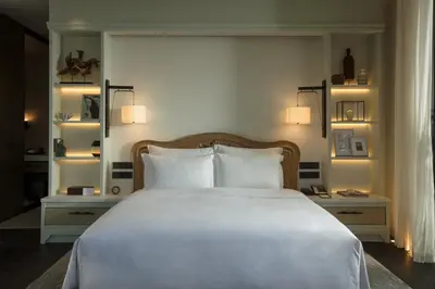 a bedroom with a large white bed with two pillows at Rosewood Phuket in Patong Beach