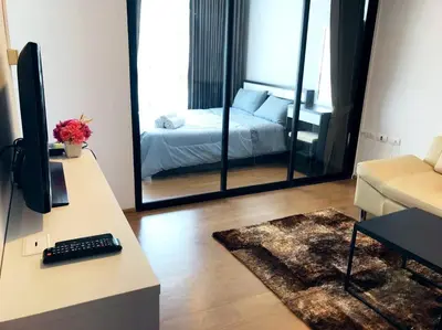 a living room with a bed and a desk with a television at 1 bedroom Centrio Condominium Phuket Near Central Festival in Phuket town in Phuket Town