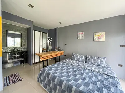 a bedroom with a bed and a desk and a sink at The Endless Bangtao Residence 1987 in Bang Tao Beach