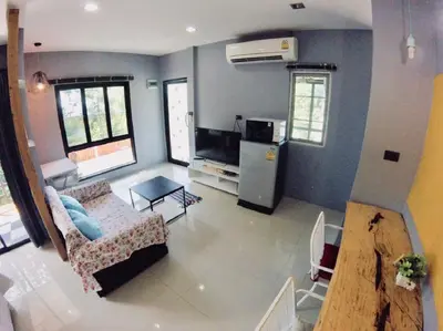 a living room with a couch and a refrigerator in a room at The Endless Bangtao Residence 1987 in Bang Tao Beach