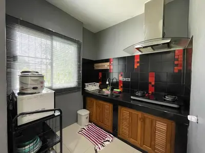 a kitchen with black and red tile on the wall at The Endless Bangtao Residence 1987 in Bang Tao Beach