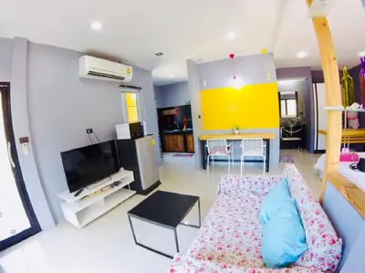 a living room with a couch and a tv at The Endless Bangtao Residence 1987 in Bang Tao Beach