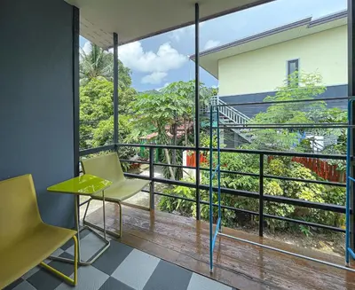 a room with a view of a balcony with a table and chair at The Endless Bangtao Residence 1987 in Bang Tao Beach