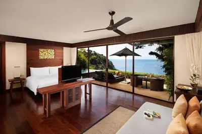 a bedroom with a bed and a view of the ocean at Paresa Resort Phuket in Kamala Beach