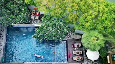 an overhead view of a swimming pool with people swimming at Mazi Design Hotel by Kalima in Patong Beach