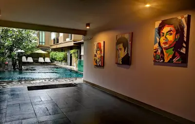 a room with paintings on the wall next to a swimming pool at Mazi Design Hotel by Kalima in Patong Beach