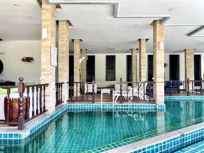 a pool in a hotel with chairs and tables at APK Resort Patong in Patong Beach
