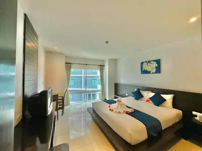 a hotel room with a large bed and a balcony at APK Resort Patong in Patong Beach