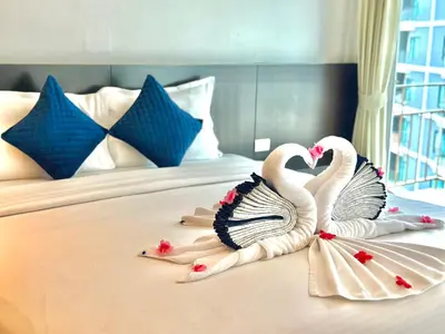 two swans are sitting on top of a bed at APK Resort Patong in Patong Beach