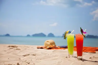 two cocktails sitting on a sandy beach at Tup Kaek Sunset Beach Resort-SHA Plus in Tab Kaek Beach