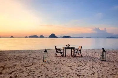a table and chairs on a beach with the ocean at Tup Kaek Sunset Beach Resort-SHA Plus in Tab Kaek Beach