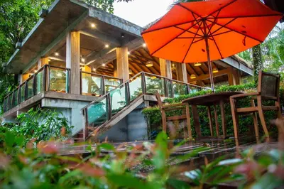 a house with a staircase and an orange umbrella at Tup Kaek Sunset Beach Resort-SHA Plus in Tab Kaek Beach