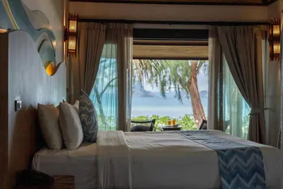 a bedroom with a bed and a large window at Tup Kaek Sunset Beach Resort-SHA Plus in Tab Kaek Beach
