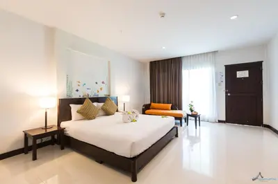 a bedroom with a large bed and a couch at Krabi Aquamarine Resort - SHA Plus in Ao Nang Beach