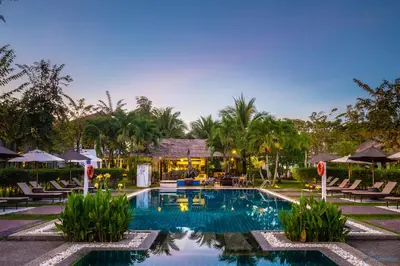 a pool at a resort with chairs and a building at Krabi Aquamarine Resort - SHA Plus in Ao Nang Beach