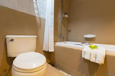 a bathroom with a toilet and a sink and a tub at Krabi Aquamarine Resort - SHA Plus in Ao Nang Beach