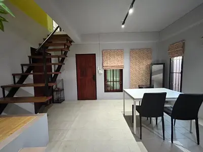 a dining room with a table and chairs and a staircase at The Endless Bangtao Residence LOFT 8 in Bang Tao Beach
