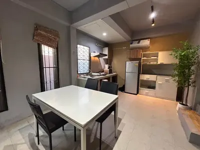 a kitchen with a white table and chairs in a room at The Endless Bangtao Residence LOFT 8 in Bang Tao Beach