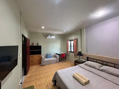a bedroom with a large bed and a desk at The Endless Bangtao Residence LOFT 8 in Bang Tao Beach