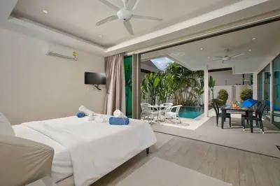 a bedroom with a white bed and a dining room at VILLA RAJA 4BR Private pool villa in Rawai Beach