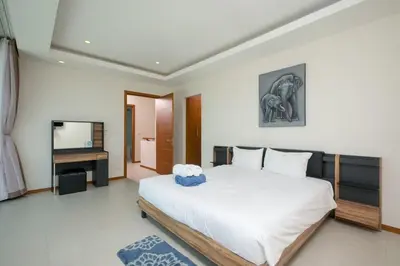 a bedroom with a large bed and a television at VILLA RAJA 4BR Private pool villa in Rawai Beach