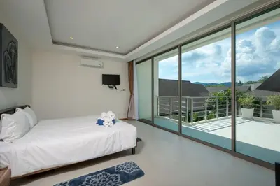 a bedroom with a bed and a balcony at VILLA RAJA 4BR Private pool villa in Rawai Beach