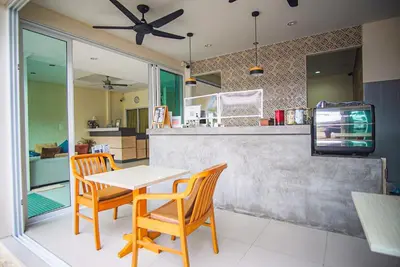 a kitchen with a table and two chairs and a tv at Capricorn Village - SHA Extra Plus in Patong Beach