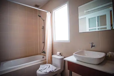 a bathroom with a sink and a toilet and a window at Capricorn Village - SHA Extra Plus in Patong Beach