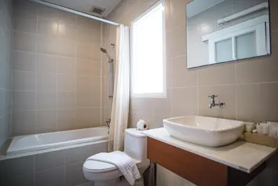 a bathroom with a sink and a toilet and a tub at Capricorn Village - SHA Extra Plus in Patong Beach