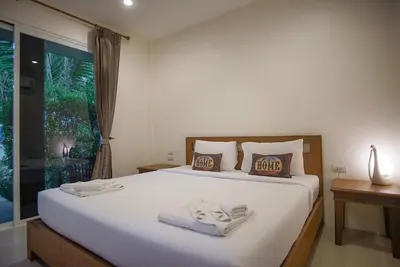 a bedroom with a bed with two towels on it at Capricorn Village - SHA Extra Plus in Patong Beach