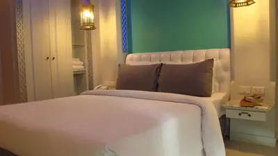 a bedroom with a white bed and a green wall at The Verandah Aonang in Ao Nang Beach