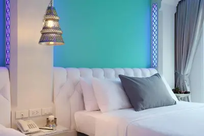 a bedroom with a white bed with a blue wall at The Verandah Aonang in Ao Nang Beach