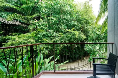 a balcony with a black railing and a chair at Renaissance Phuket Resort & Spa in Mai Khao Beach