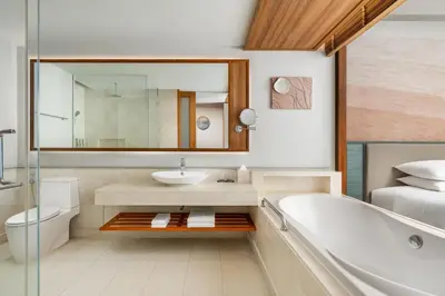 a bathroom with a tub and a sink and a toilet at Renaissance Phuket Resort & Spa in Mai Khao Beach